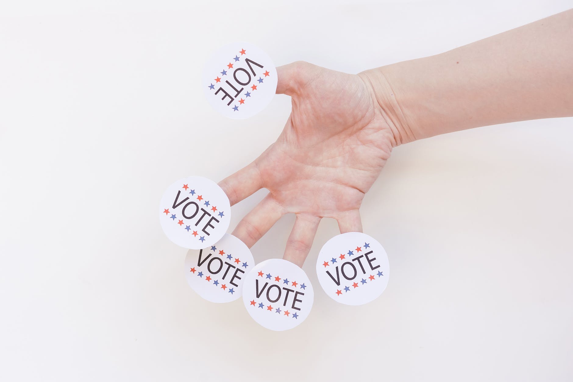 vote badges on person s fingers